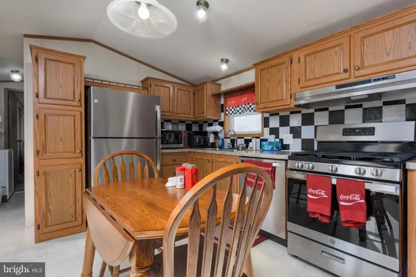 a kitchen with stainless steel appliances granite countertop a refrigerator and a stove top oven