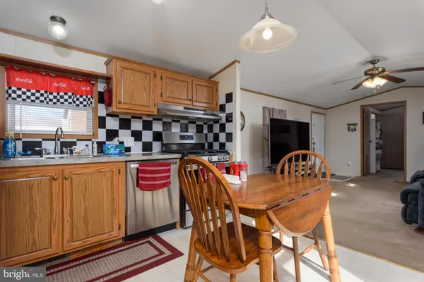 a kitchen with stainless steel appliances granite countertop a sink dishwasher and a refrigerator with wooden cabinets