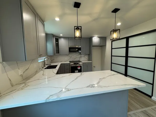 a kitchen with stainless steel appliances kitchen island a refrigerator sink and cabinets