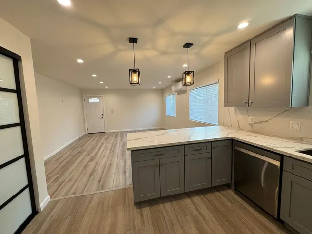 a kitchen with a sink and wooden floor
