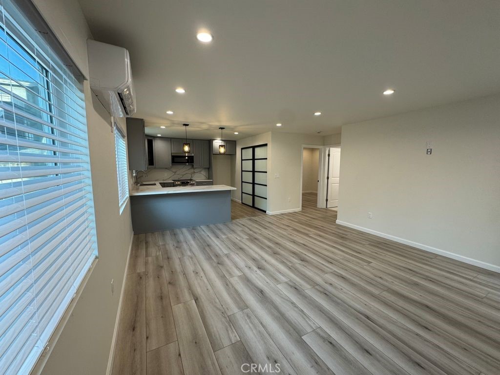7149 Apperson Street, Unit 2 Tujunga, CA 91042 - Photo 7 of 12 a view of a hallway with wooden floor and chandelier