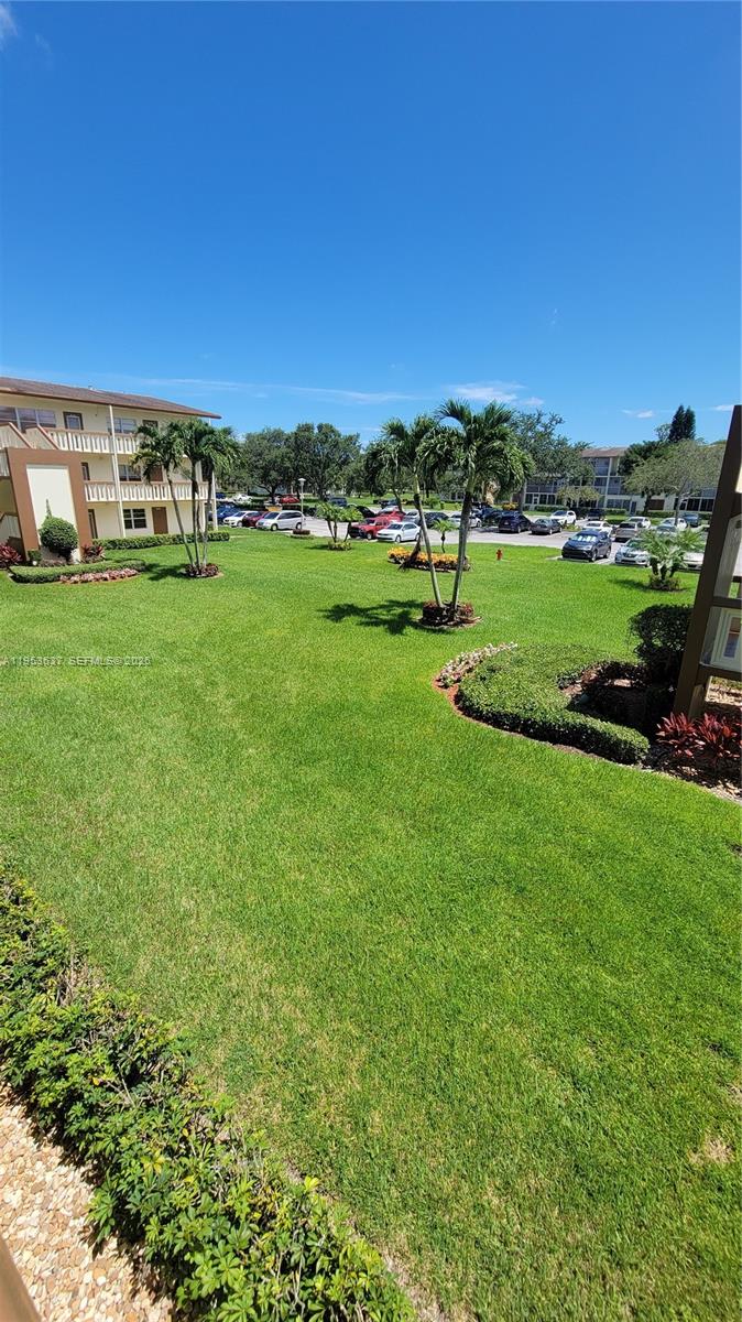 272 Mansfield H, Unit 272 Boca Raton, FL 33434 - Photo 14 of 17 a view of a big yard with a house in the background