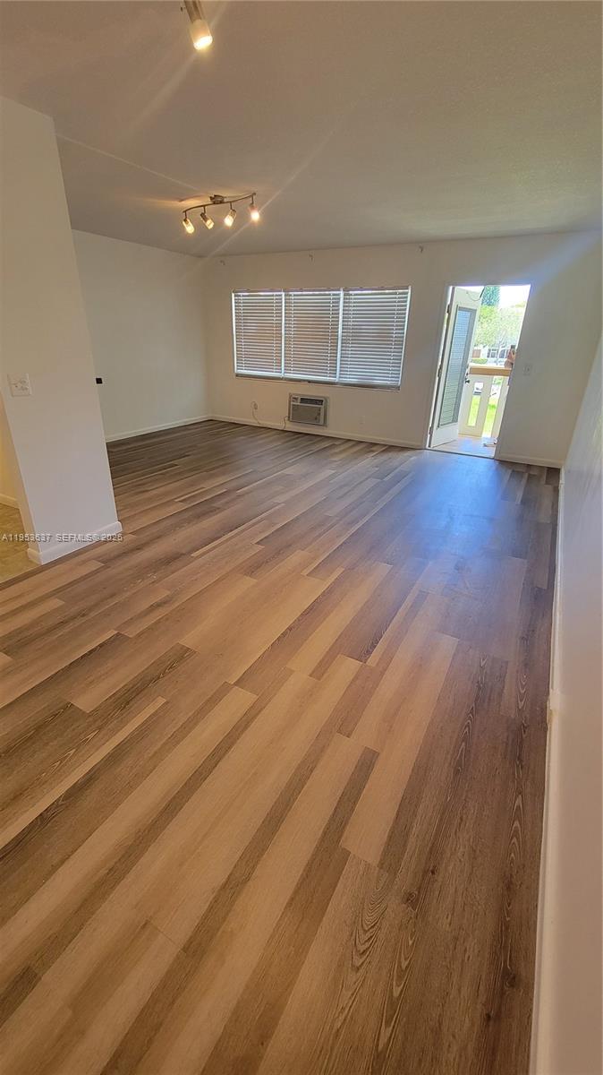 272 Mansfield H, Unit 272 Boca Raton, FL 33434 - Photo 4 of 17 a view of an empty room with wooden floor and a window