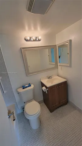 a bathroom with a toilet a sink and mirror