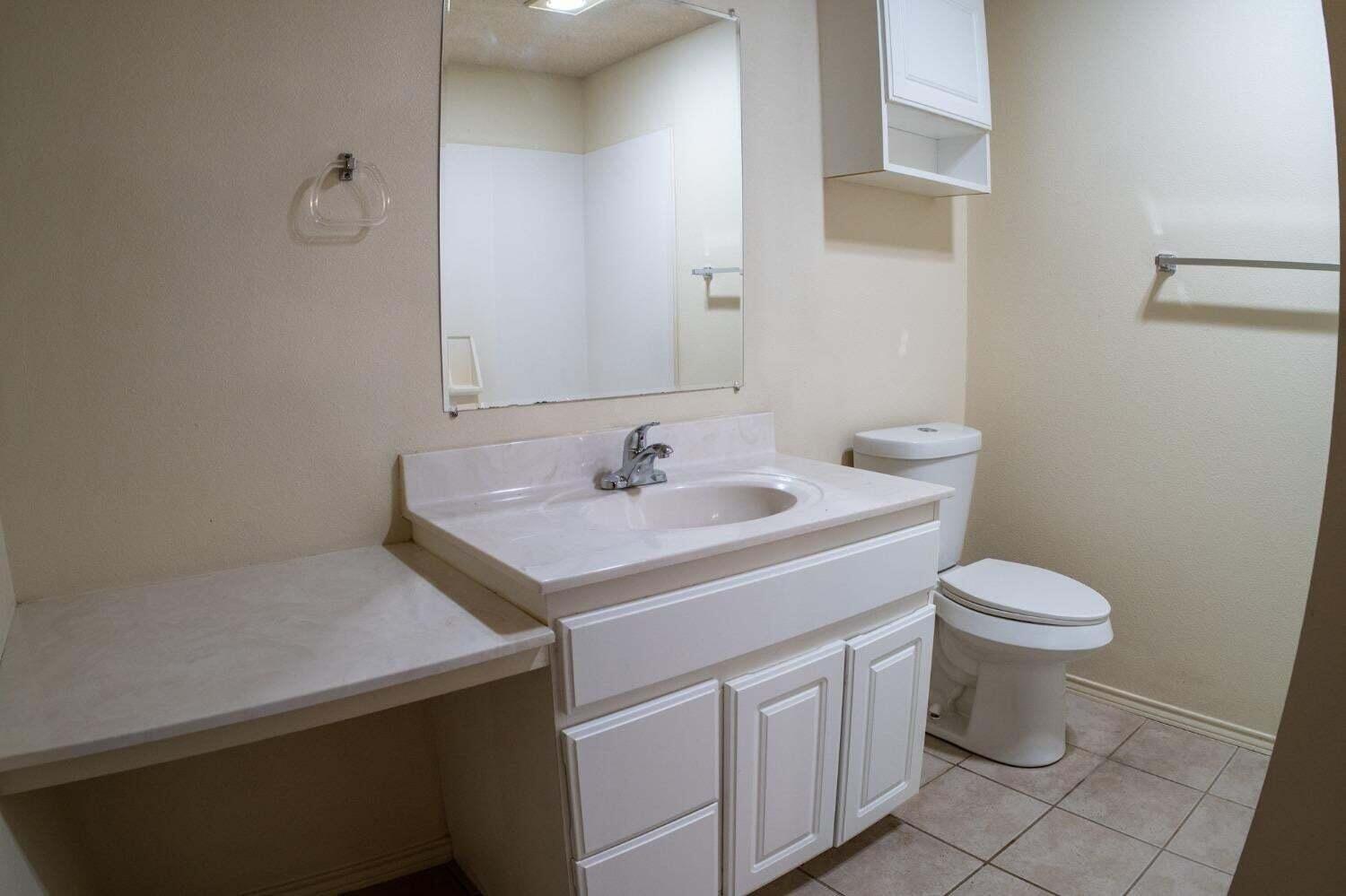 3417 97th Street Lubbock, TX 79423 - Photo 14 of 21 a bathroom with a sink toilet and a mirror