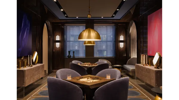 a dining hall with furniture and a kitchen view