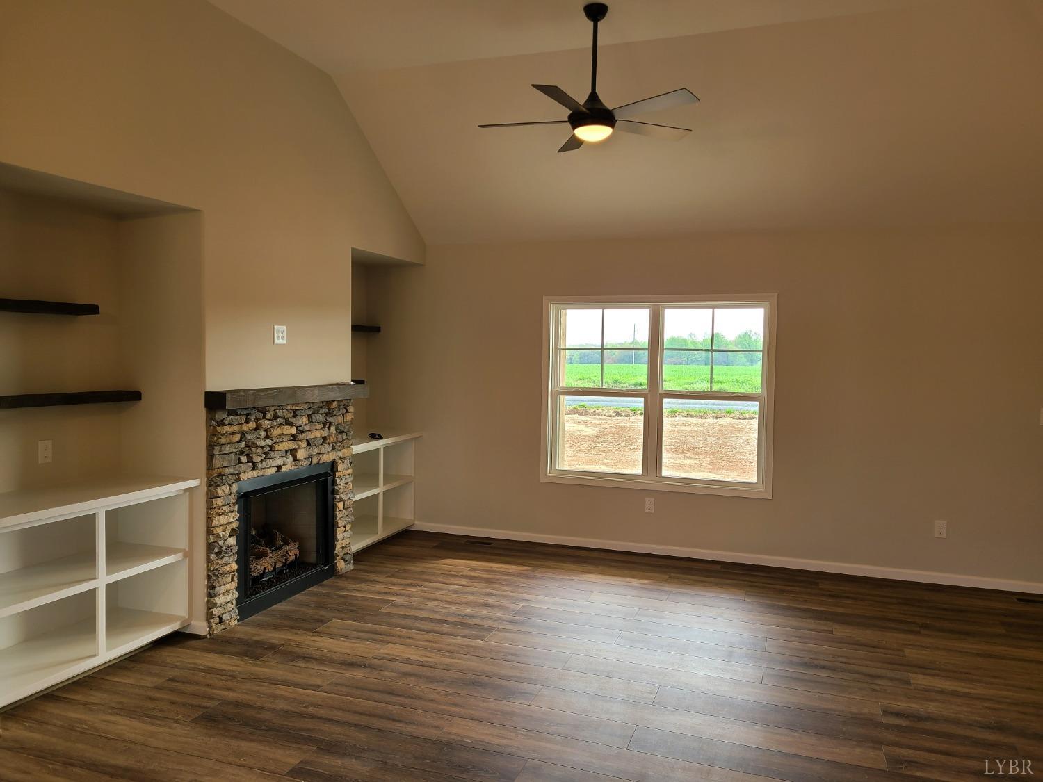 3353 Stonewall Road Concord, VA 24538 - Photo 4 of 21 an empty room with wooden floor fireplace and windows