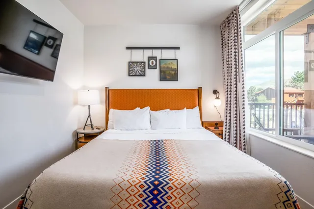 a bedroom with a large bed and a tv on a dresser