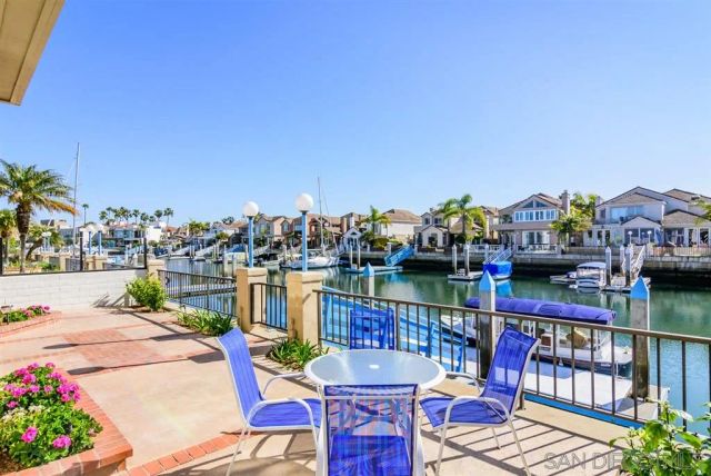 a balcony with couple of chairs and potted plants