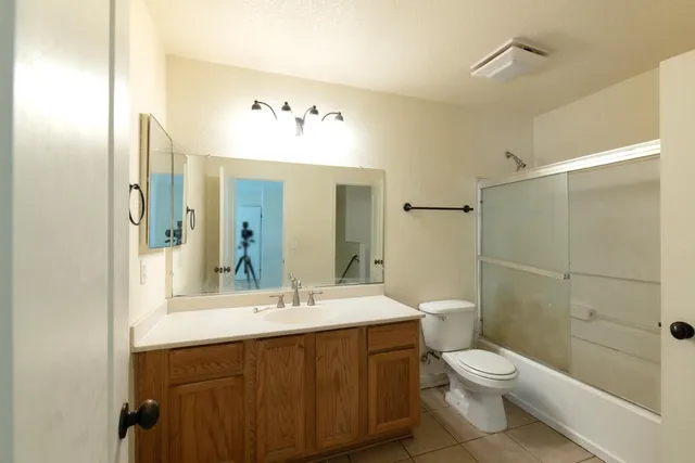 a bathroom with a bathtub shower sink mirror and toilet