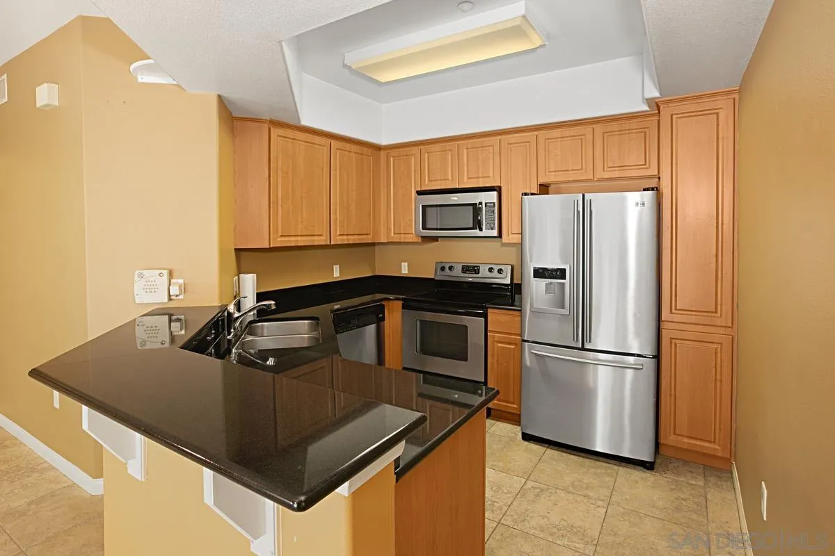 2715 Lake Pointe Drive, Unit 121 Spring Valley, CA 91977 - Photo 7 of 27 a kitchen with stainless steel appliances granite countertop a sink a refrigerator and a stove