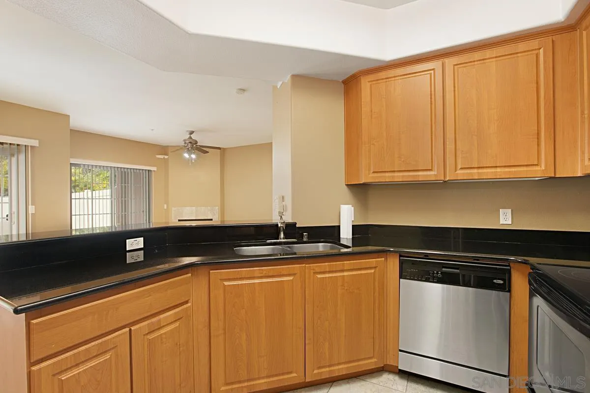 2715 Lake Pointe Drive, Unit 121 Spring Valley, CA 91977 - Photo 9 of 27 a kitchen with stainless steel appliances granite countertop a sink a stove a counter space and cabinets