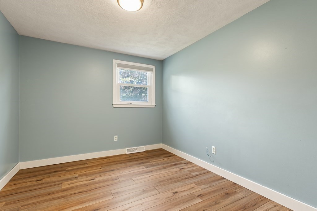 3 Proctor Road Townsend, MA 01469 - Photo 12 of 19 a view of an empty room with wooden floor and a window