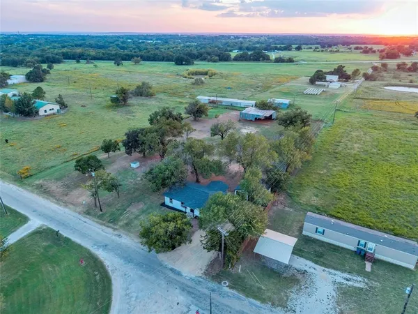 an aerial view of green landscape with trees houses and mountain view