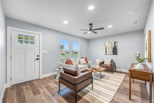 a living room with furniture and a ceiling fan