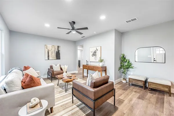 a living room with furniture and a wooden floor
