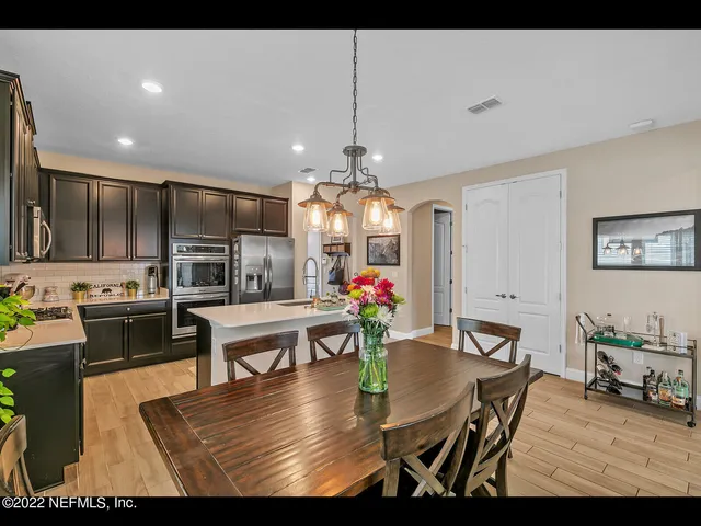 a view of a dining room with furniture a chandelier and wooden floor