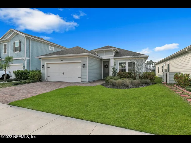 a front view of a house with a garden and yard