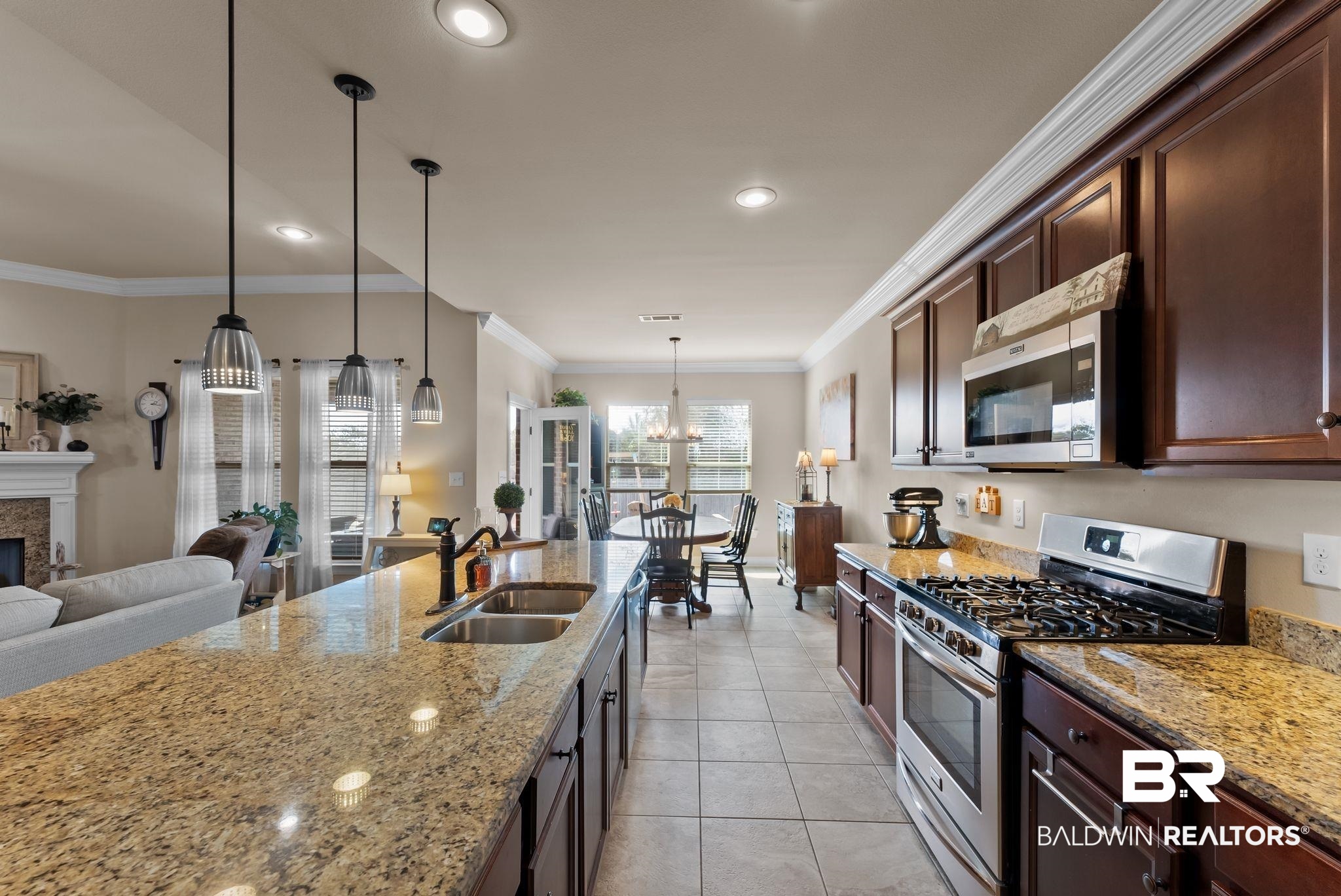 7015 Rocky Rd Loop Gulf Shores, AL 36542 - Photo 41 of 41 Kitchen with stainless steel appliances, ornamental molding, light stone counters, open floor plan, and a fireplace