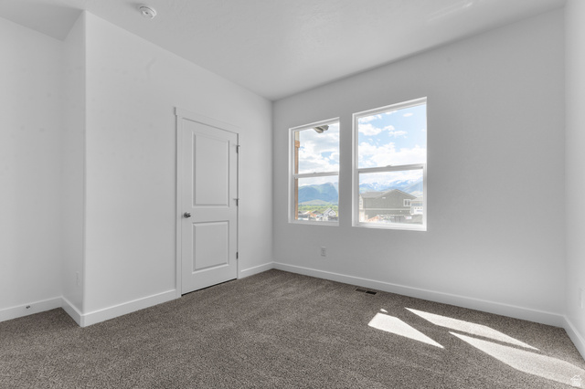 1338 West 2350 South, Unit 19 Perry, UT 84302 - Photo 8 of 14 Bright room featuring two large windows, white walls, and plush grey carpet