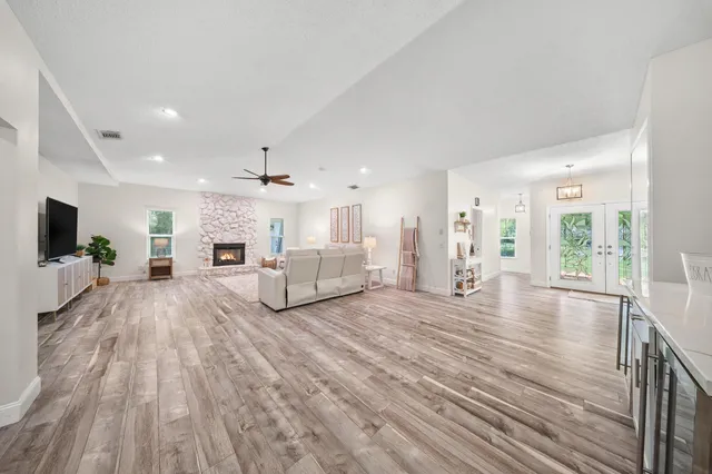 a large white room with kitchen island a flat screen tv