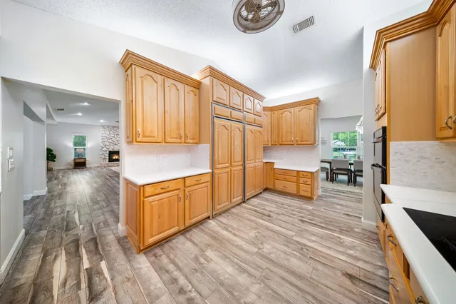 a large kitchen with stainless steel appliances wooden floors and wooden cabinets