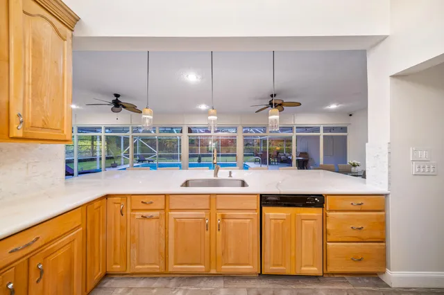 a view of a dining room and livingroom with furniture wooden floor a chandelier