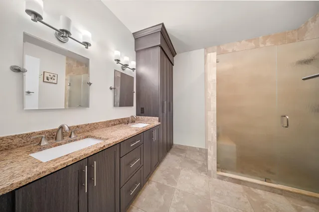 a spacious bedroom with a large bed and a chandelier