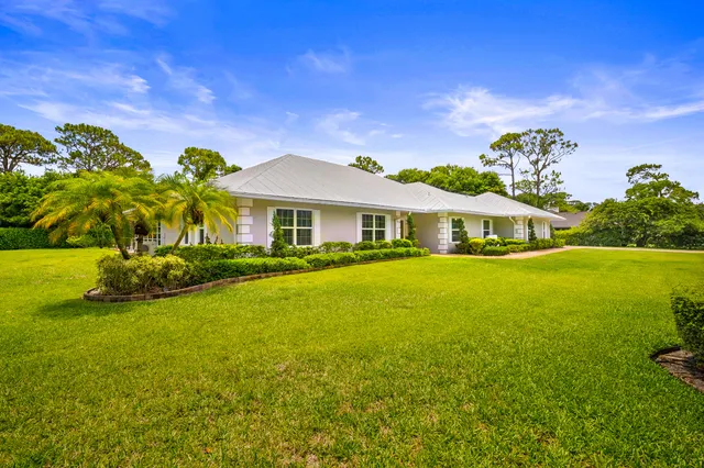 an aerial view of a house with swimming pool and garden