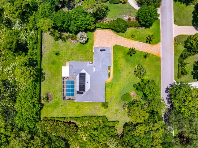 an aerial view of a house with a swimming pool and garden