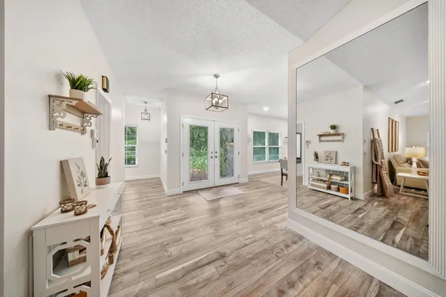 a living room with furniture large window and wooden floor