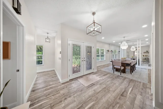 a view of a livingroom with furniture wooden floor and a chandelier