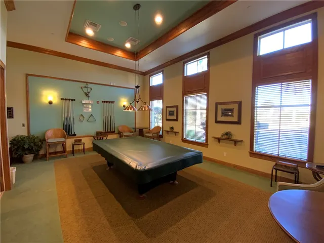 a living room with furniture pool table and a large window
