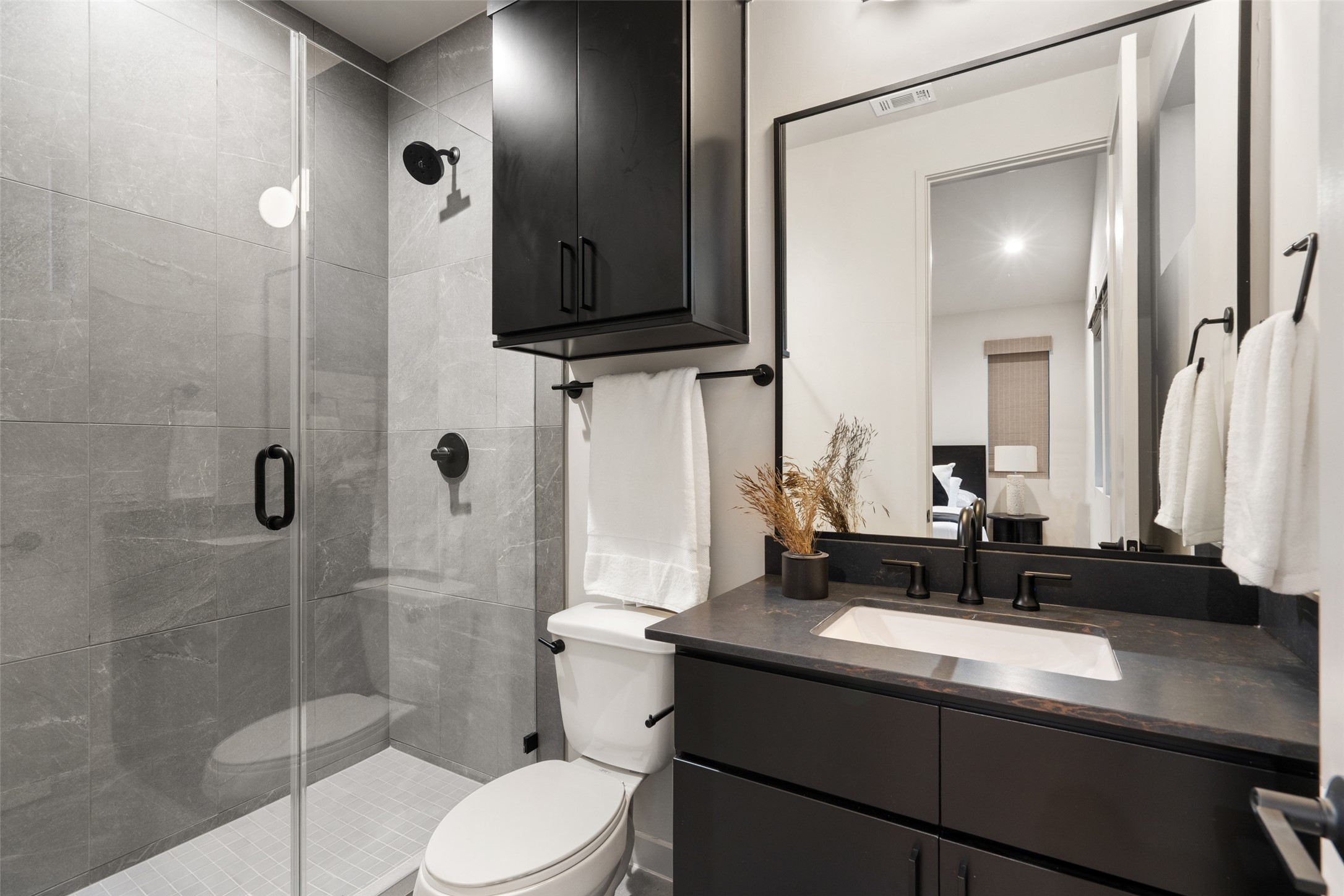 9803 Ribelin Ranch Court, Unit 6 Austin, TX 78750 - Photo 23 of 31 A well-appointed bathroom with dark fixtures and sleek tiled shower, maximizing style and utility.