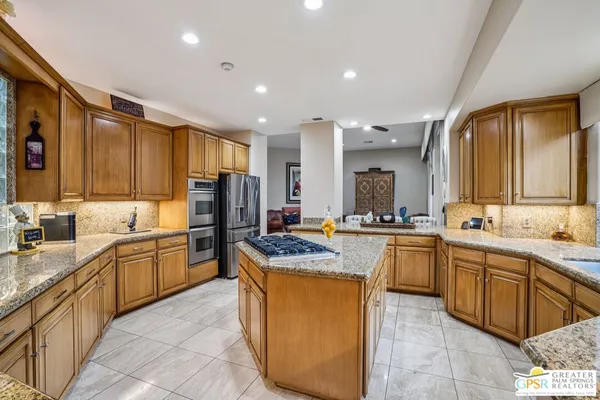 a kitchen with stainless steel appliances granite countertop a sink counter space cabinets and a large window