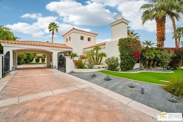 a front view of a house with a yard and potted plants