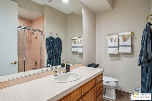 a bathroom with a granite countertop sink toilet and mirror