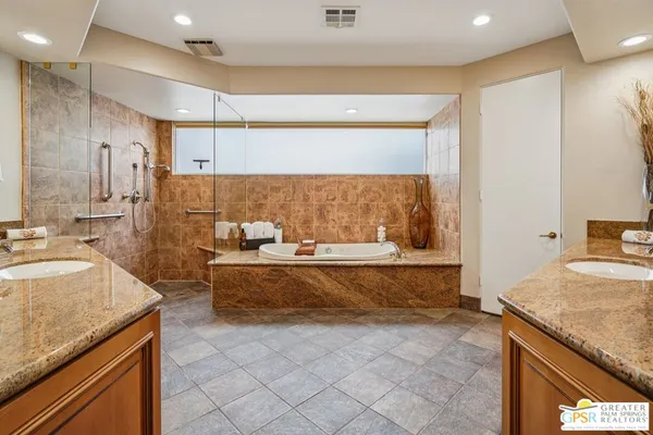 a large bathroom with a granite countertop sink a large mirror and a bathtub