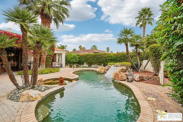 a view of swimming pool with a patio and a garden