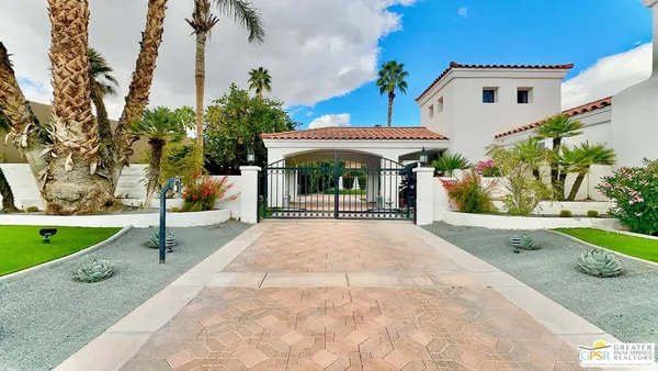 a view of a car park in front of a house with a fountain
