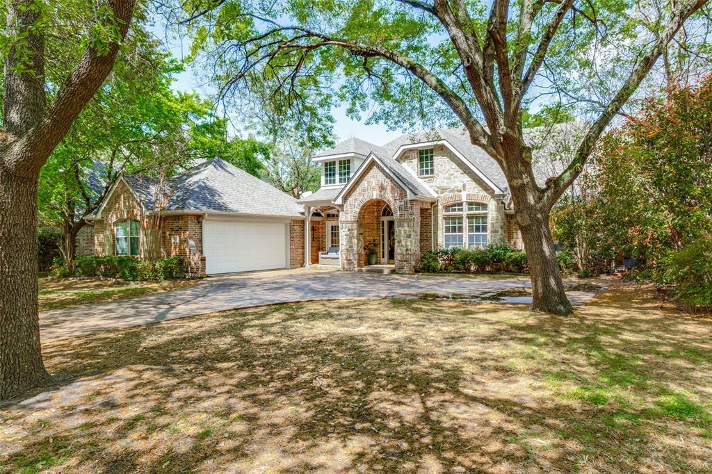 a front view of a house with a garden and tree
