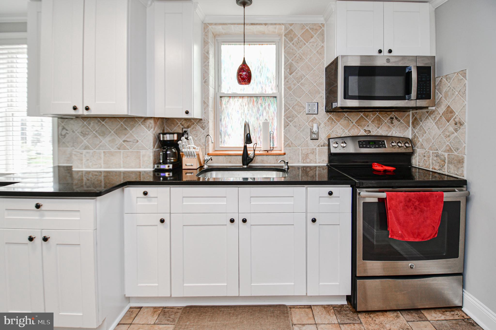 5934 Conover Road Taneytown, MD 21787 - Photo 2 of 38 a kitchen with stainless steel appliances granite countertop a stove a microwave and cabinets