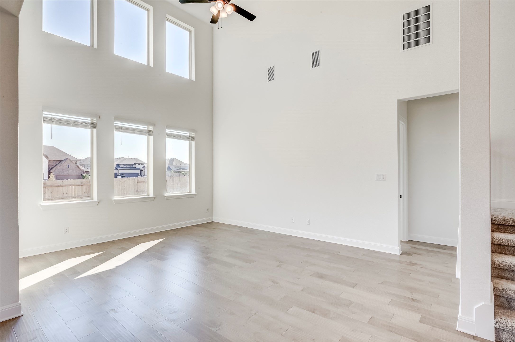 920 Old Gdn Road Leander, TX 78641 - Photo 7 of 39 Unfurnished room featuring a high ceiling, light wood finished floors, ceiling fan, and stairs