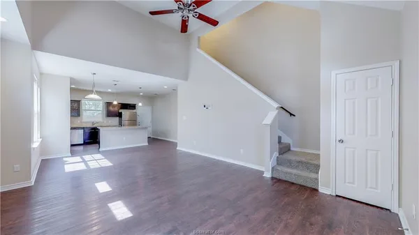 a view of a livingroom with wooden floor and staircase