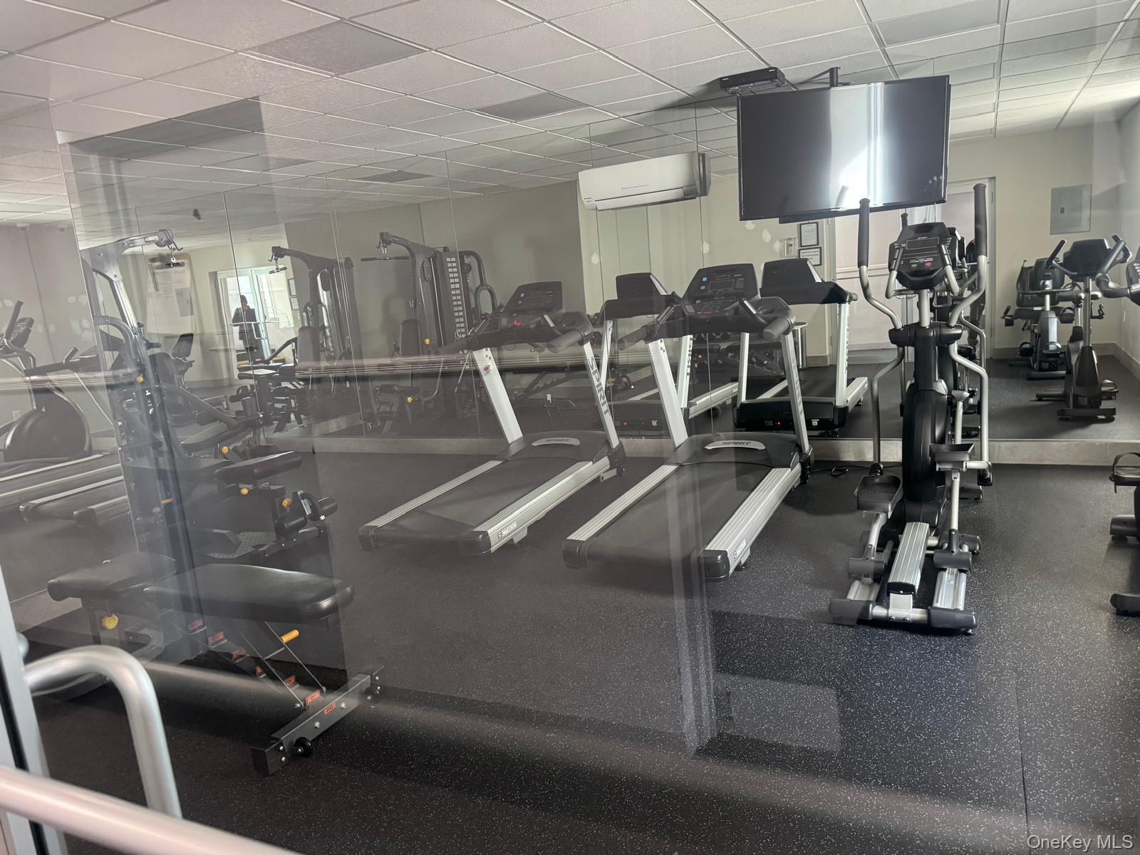 666 Shore Road Long Beach, NY 11561 - Photo 21 of 22 Workout area with a paneled ceiling, a wall mounted air conditioner, and electric panel