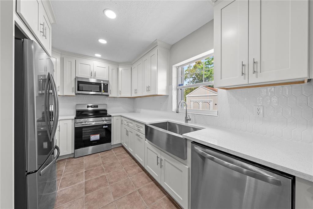 750 West New Nolte Road St. Cloud, FL 34769 - Photo 35 of 59 a kitchen with kitchen island white cabinets appliances and a window