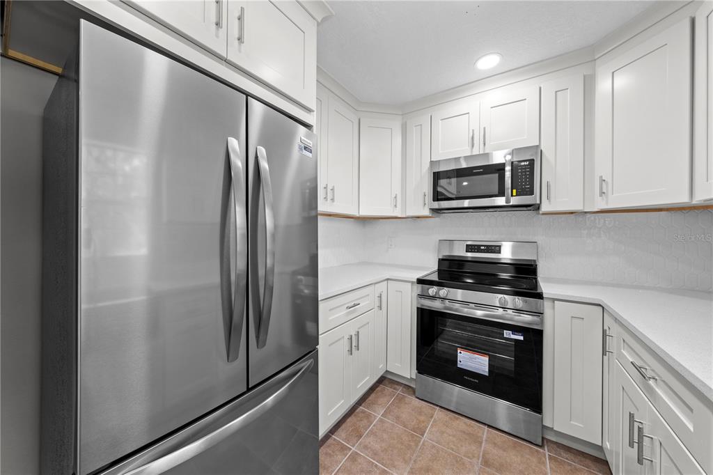 750 West New Nolte Road St. Cloud, FL 34769 - Photo 39 of 59 a kitchen with stainless steel appliances granite countertop a refrigerator stove and microwave