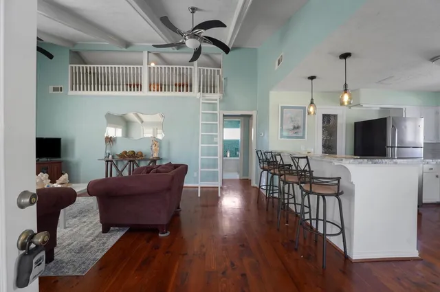 a living room with furniture a flat screen tv and a floor to ceiling window