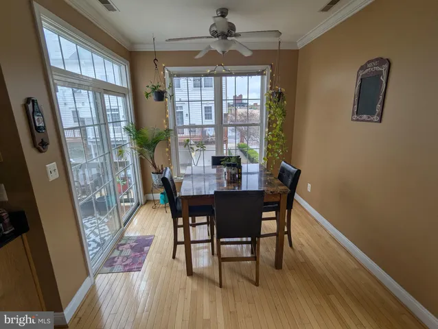 a view of a kitchen with fridge and wooden floor