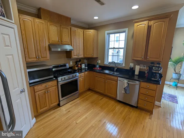 a kitchen with stainless steel appliances granite countertop a refrigerator stove and sink